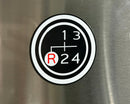 Gear shift emblem with numbers 1, 3, R, and 24 on a metallic surface